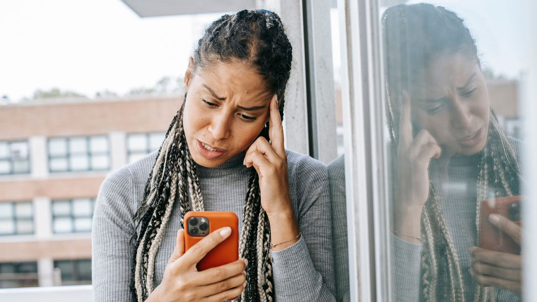 a woman confused over a phone over an unknown caller id