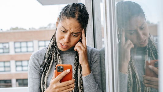 a woman confused over a phone over an unknown caller id