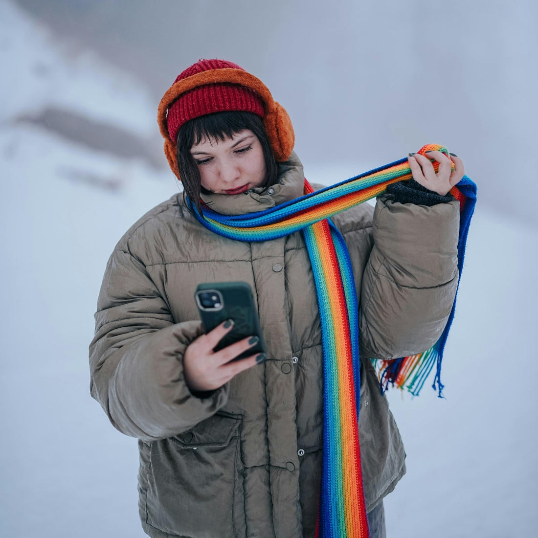 a woman using her phone in winter and snow