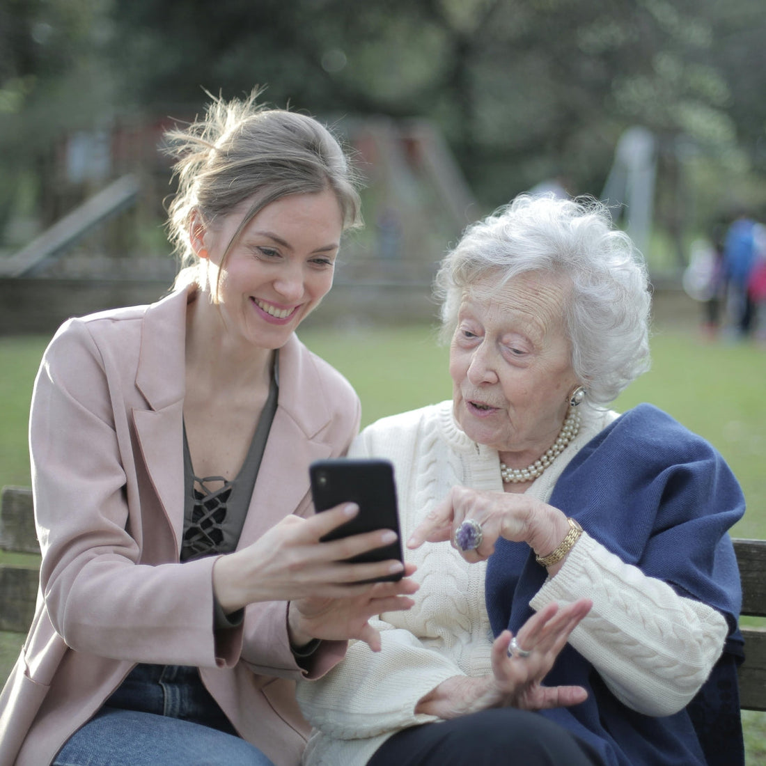 a woman showing her elderly mother how a smartphone works