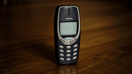 Nokia 3310 phone on a wooden surface with a dark background