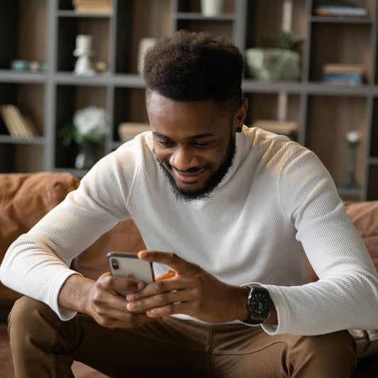 a man using his phone and smiling because it's sim free